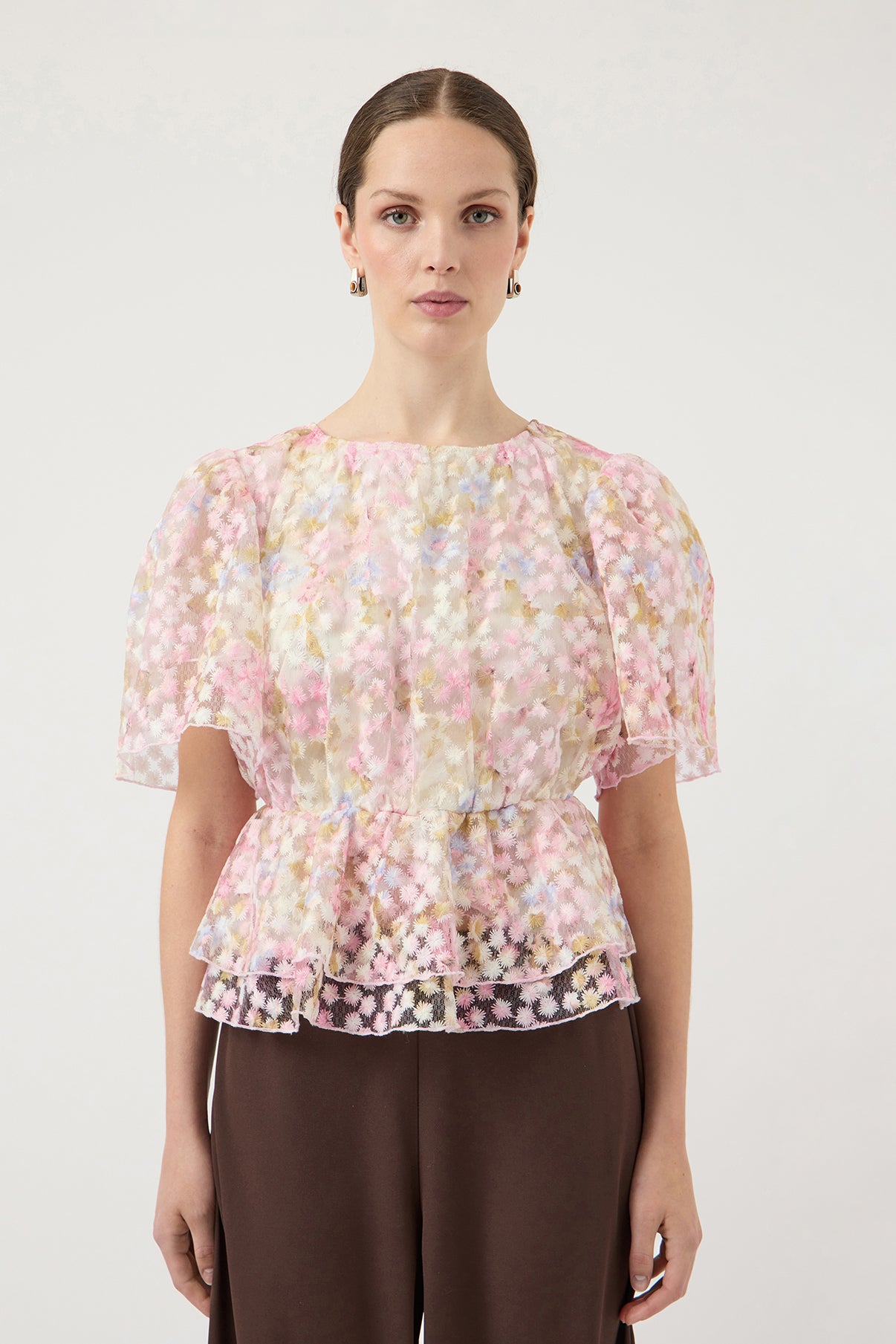 Lyserød kortærmet bluse med blomsterprint og pufærmer, taljeret design.
