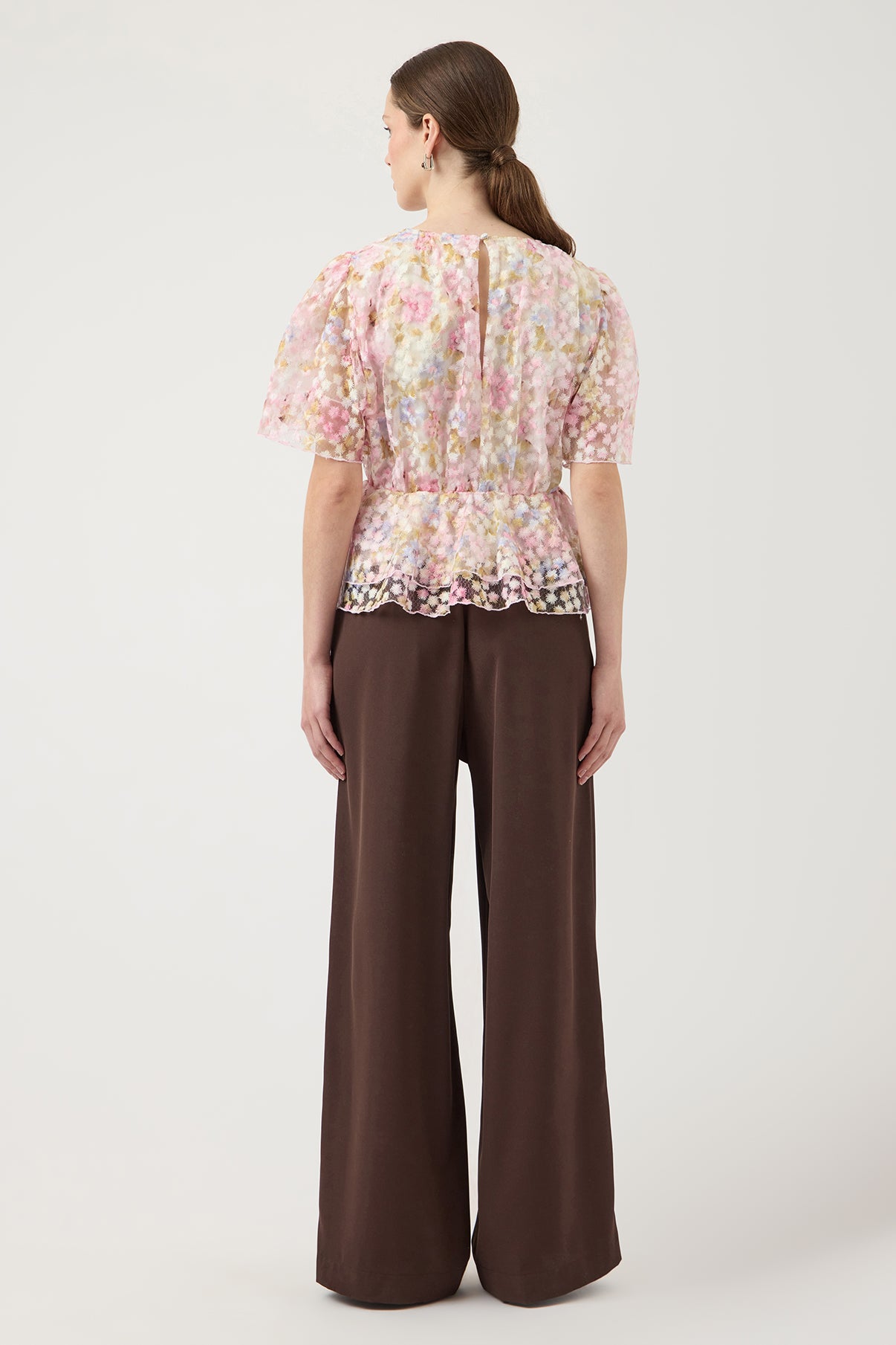 Kortærmet bluse med pufærmer i lyst blomstermønster og let peplum ved taljen.