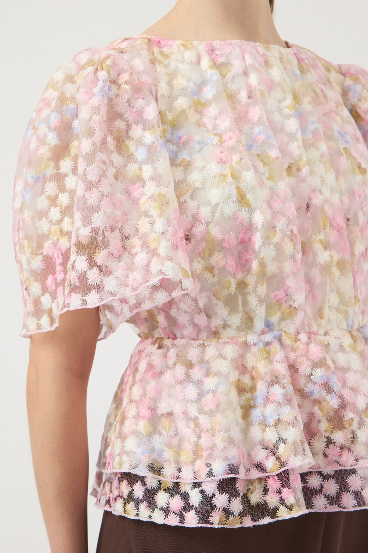 Kortærmet bluse i let gennemsigtigt stof med lyserøde og hvide blomsterprint og pufærmer.