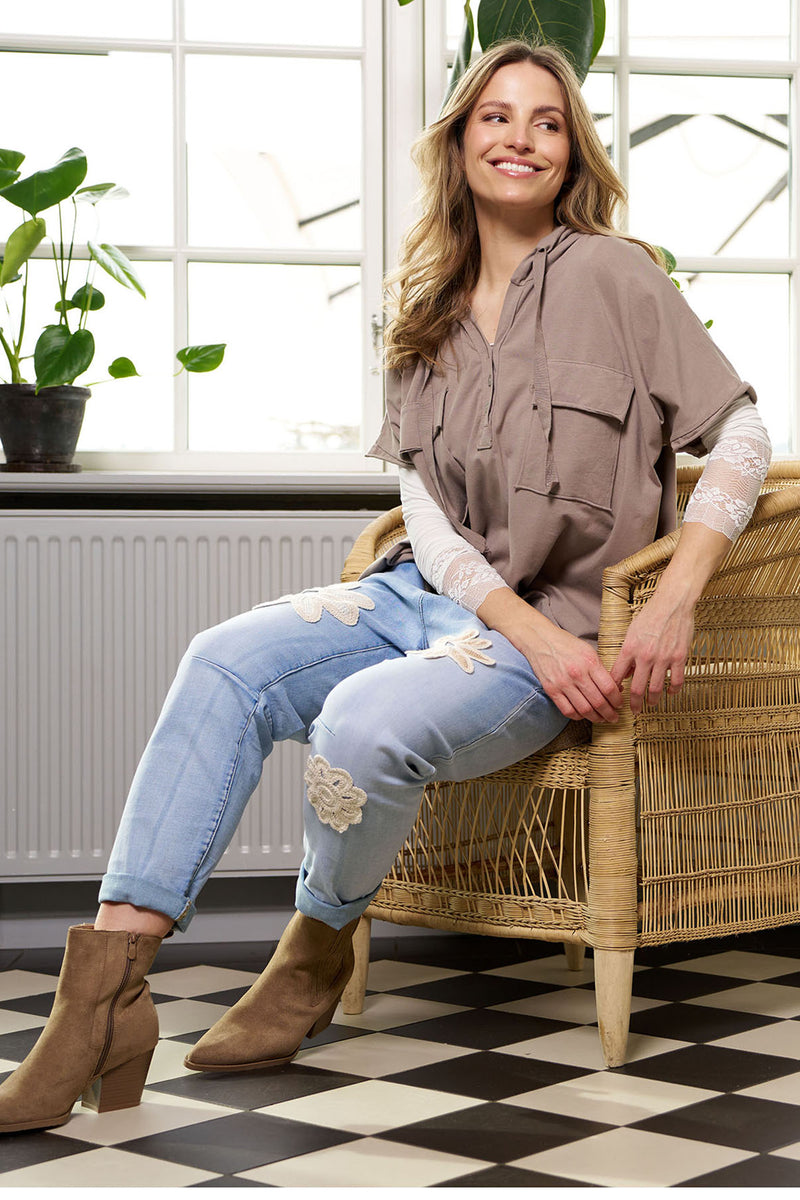 Kortærmet bluse med hætte i fango, lommer og løs pasform, stylet med lys langærmet top og broderede jeans.