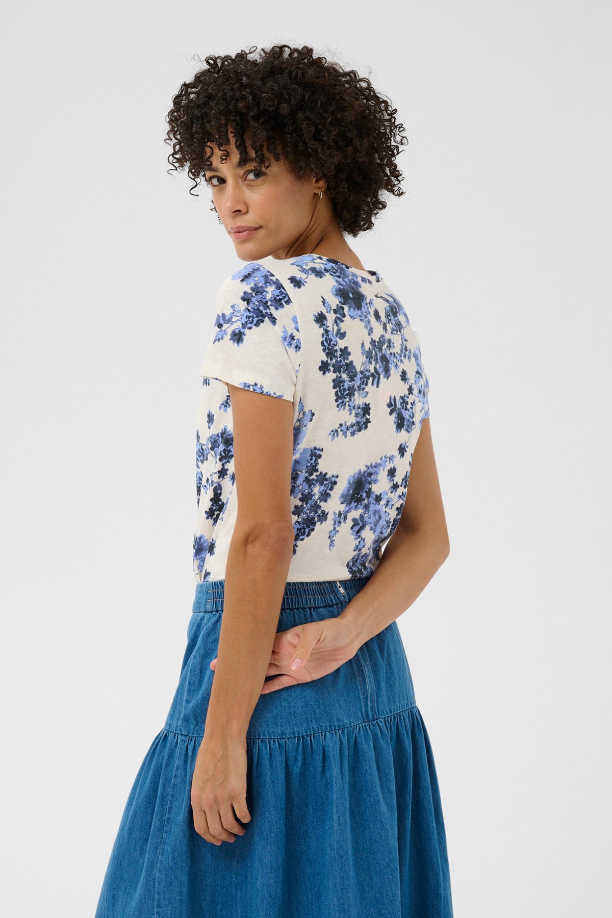 Kortærmet bluse med hvid bund og blå blomsterprint, rund hals og afslappet pasform.