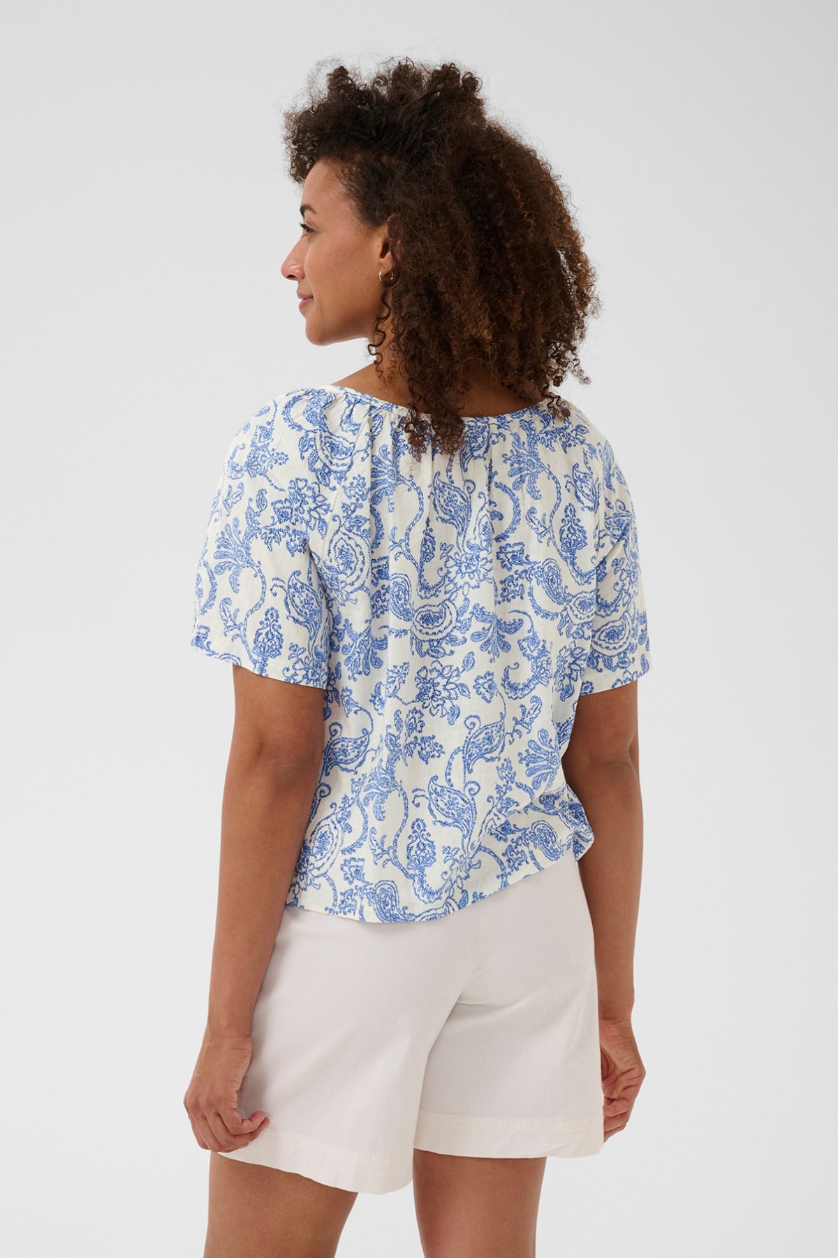 Kortærmet bluse i blå paisleyprint i hør-viskose med rund hals og løs pasform.