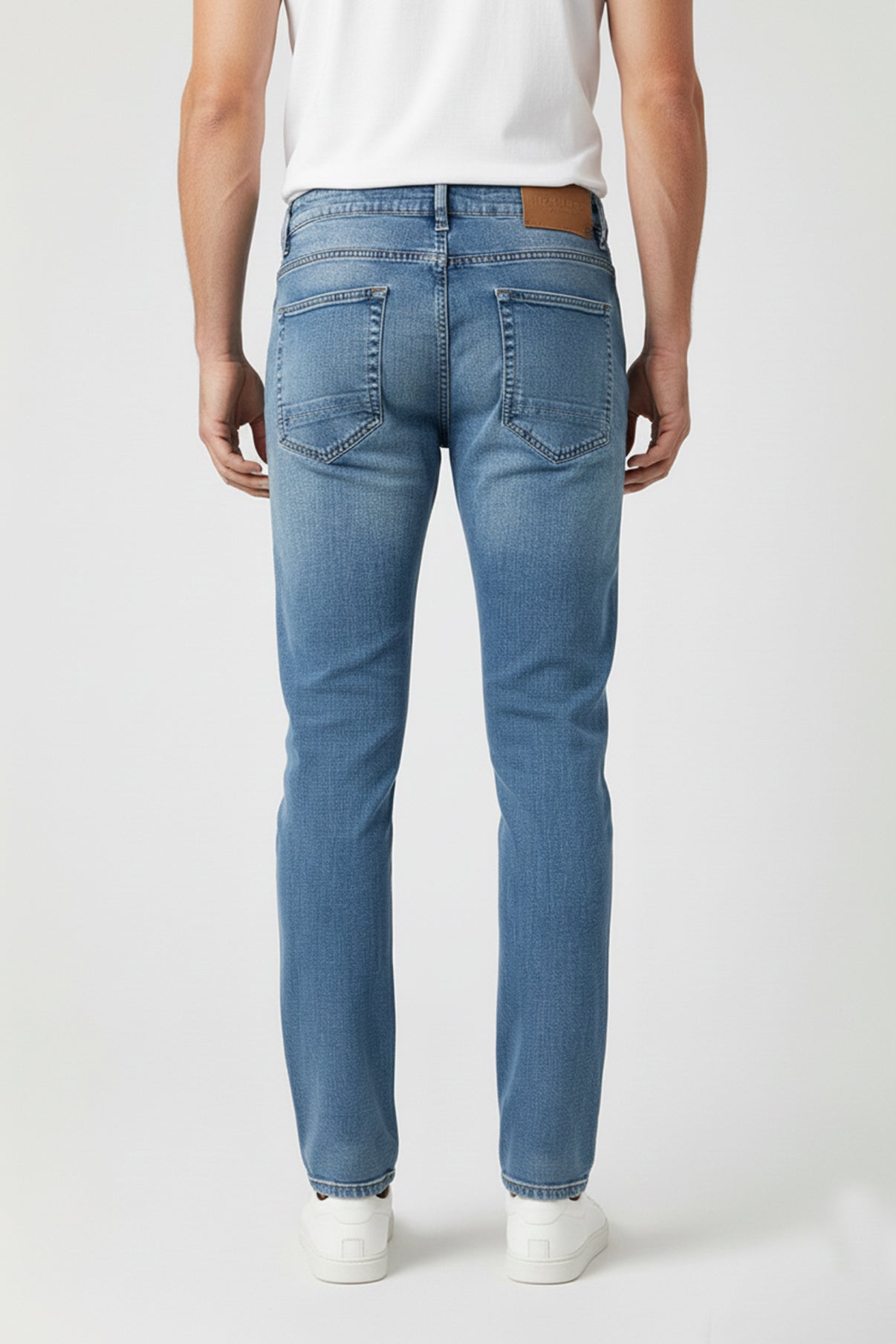 Blå denim stretch-jeans med smal pasform og slidte detaljer bagpå, model set bagfra.
