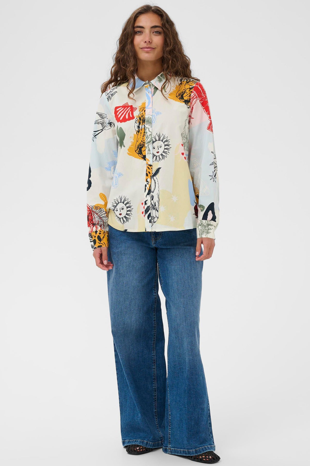 Langærmet skjorte med blå-rødt dyreprint og knapper, stylet med mørkeblå vide jeans.