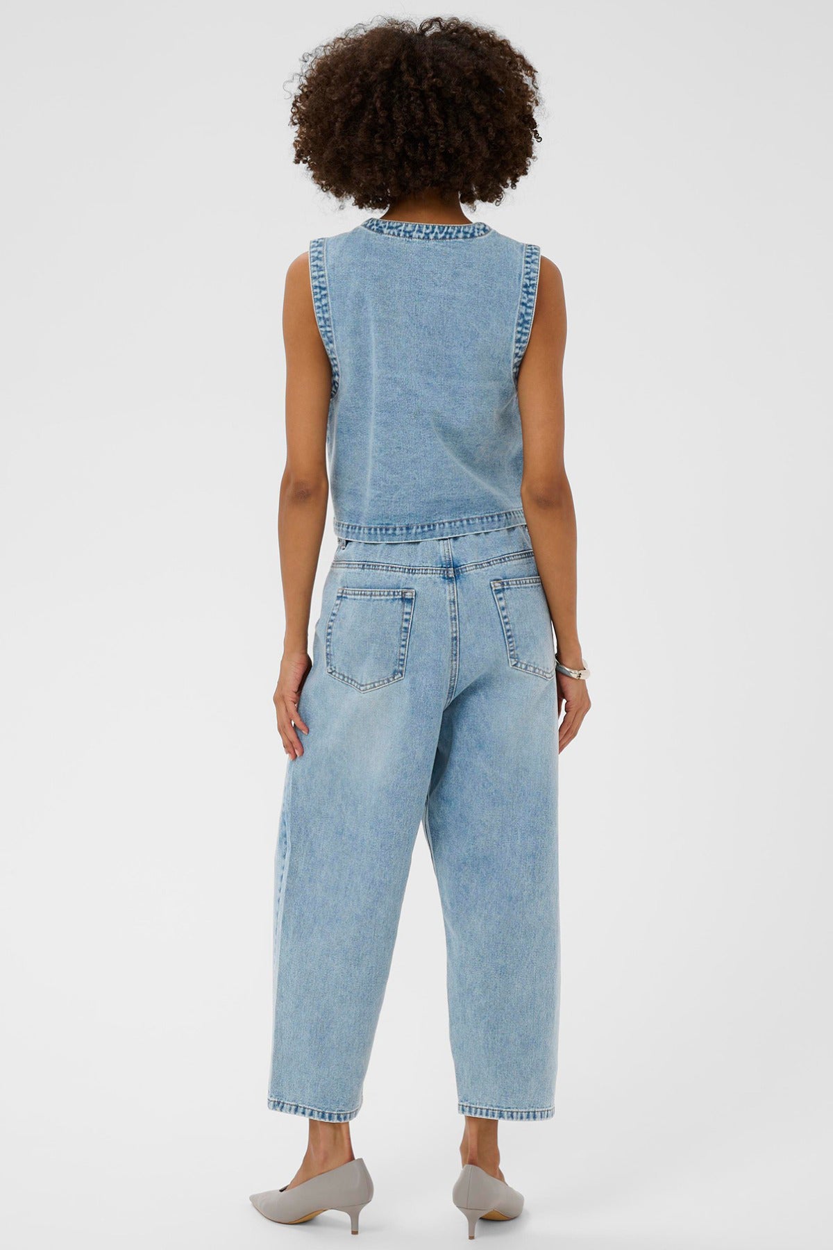 Lys blå denim vest uden ærmer med broderede detaljer set bagfra.