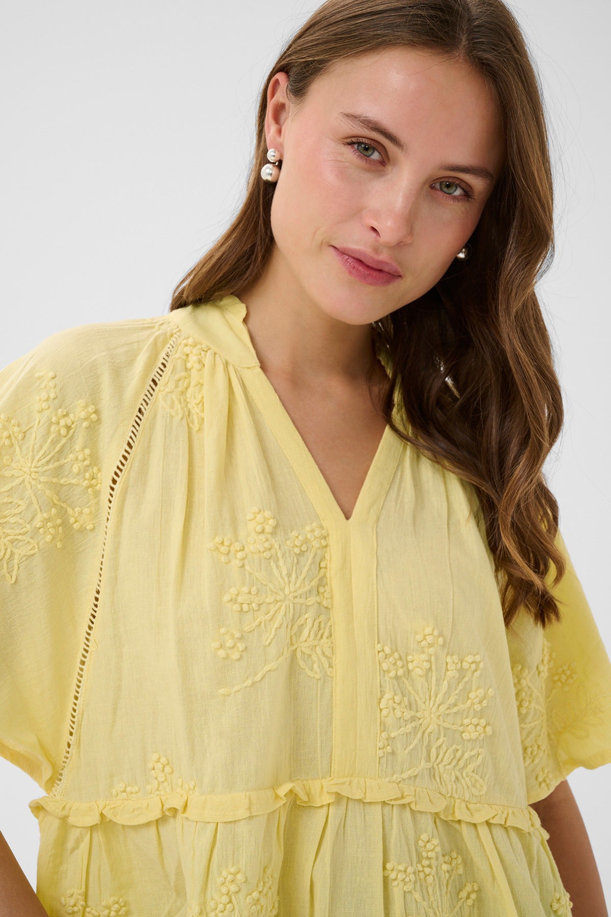 Kortærmet lemon meringue bluse med V-hals og broderede blomsterdetaljer.