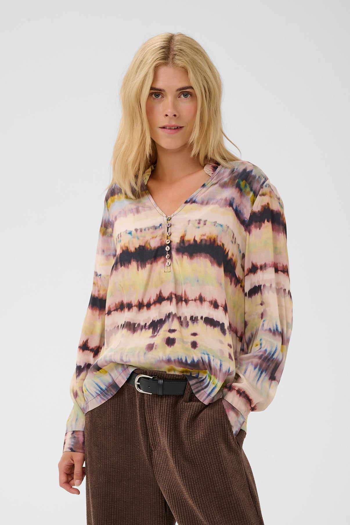 Langærmet bluse med burgundy-grønne flerfarvede tie-dye mønstre og V-hals.