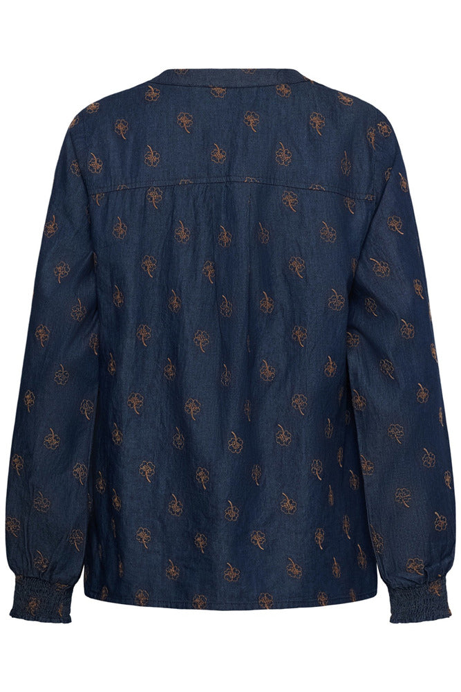 Langærmet blå bluse i denim med orange broderede blomster og elastiske manchetter bagpå.