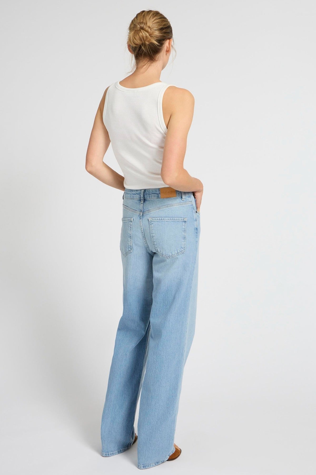 Lyseblå ultra højtaljede jeans med brede ben og baglommer, set bagfra.