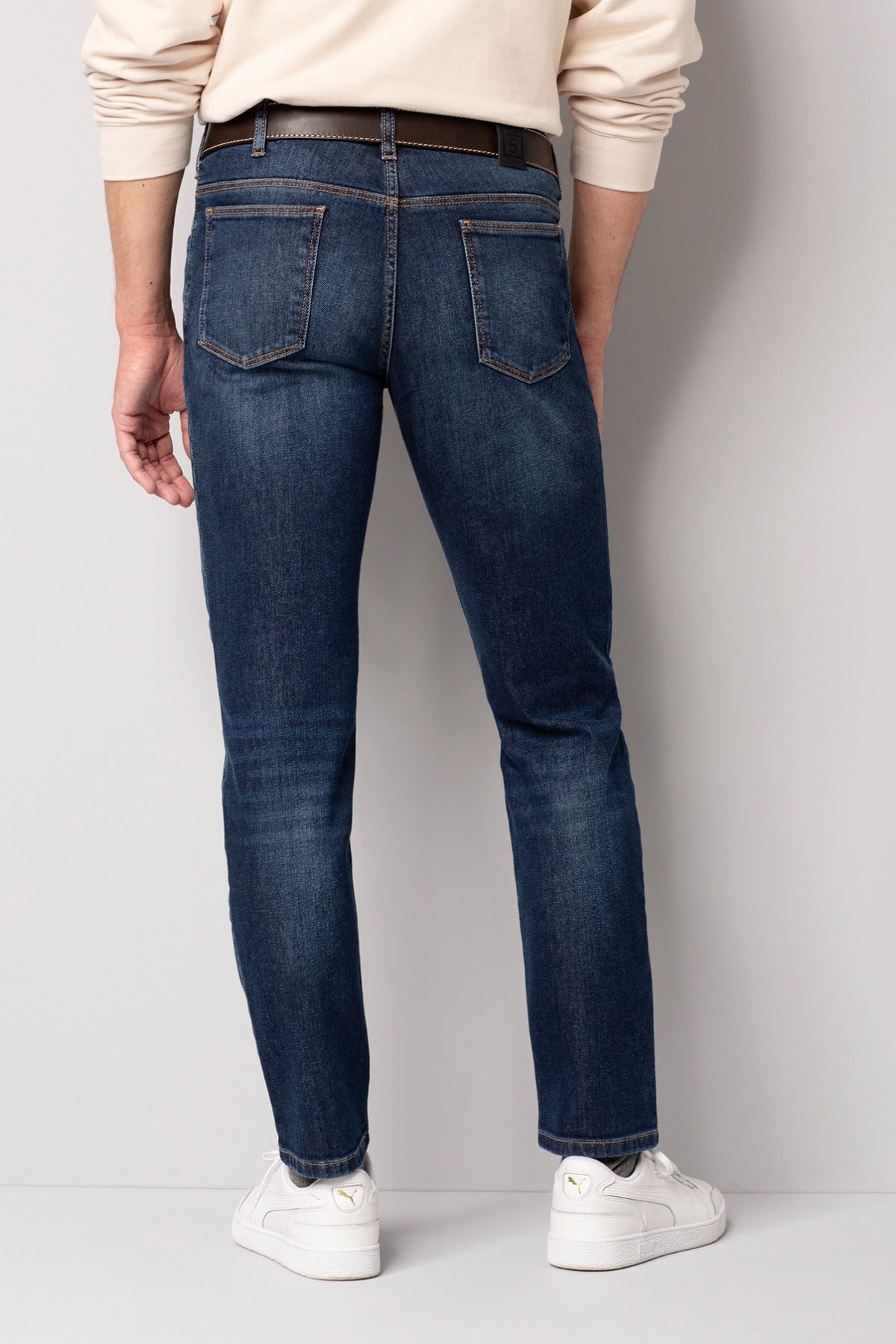 Blå slim fit jeans med let vask og baglommer, set bagfra.
