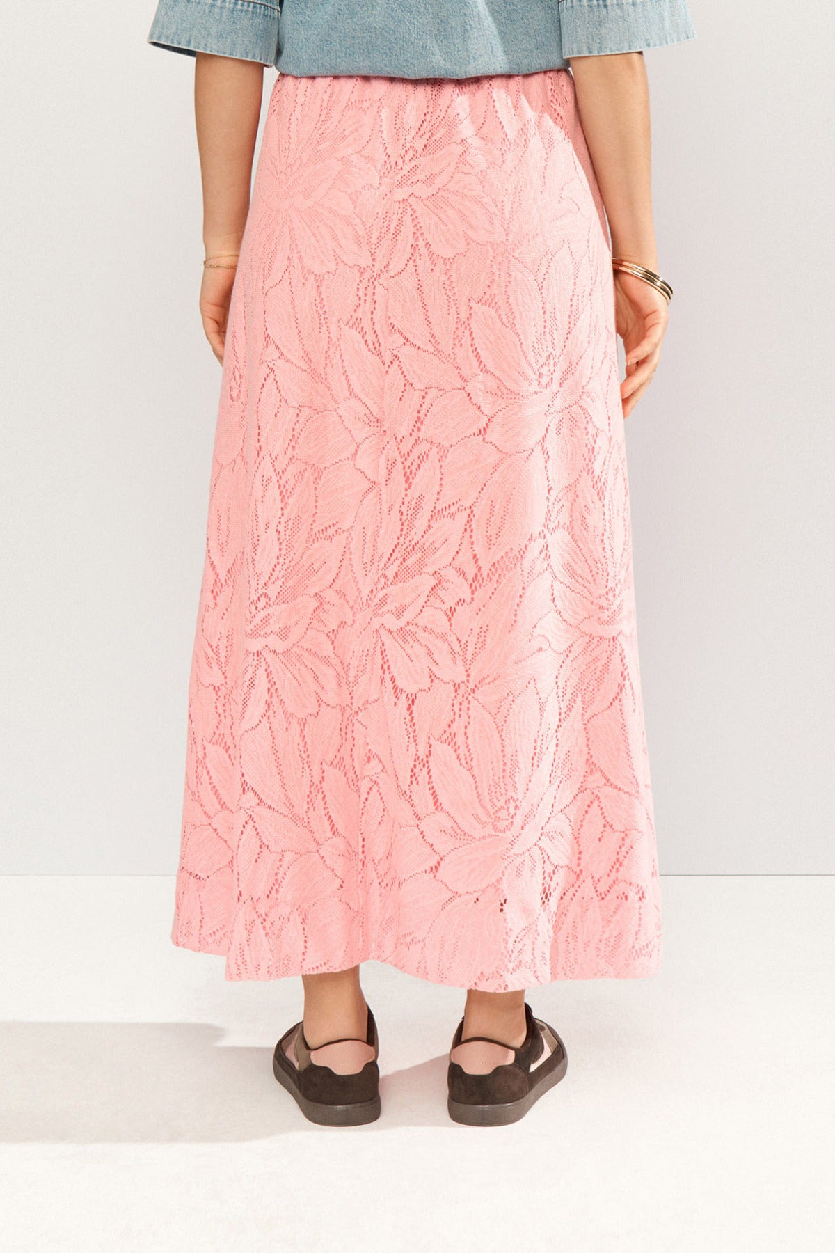 Lang pink blonde-nederdel med blomsterstruktur og let A-formet silhuet.