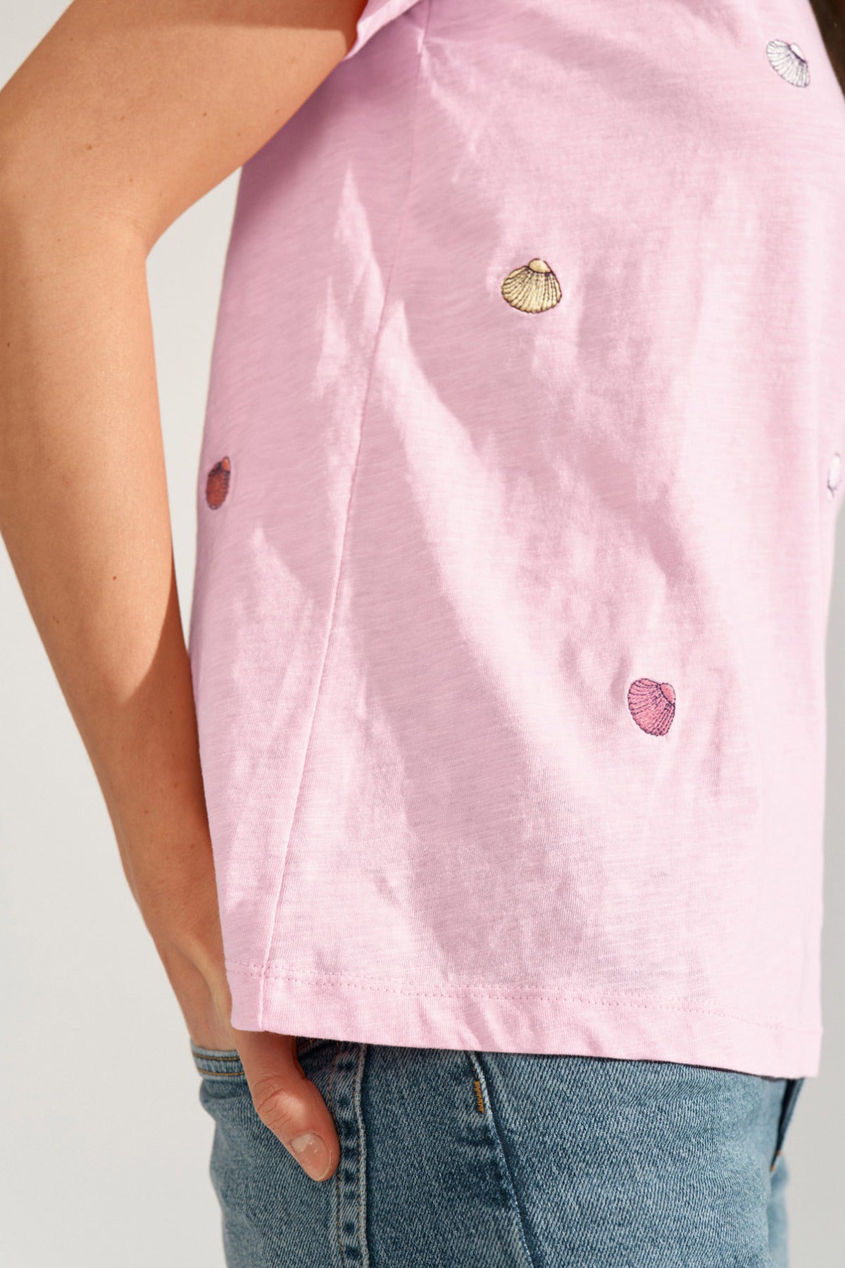 Lyserød t-shirt med broderede muslingedetaljer og rund hals.