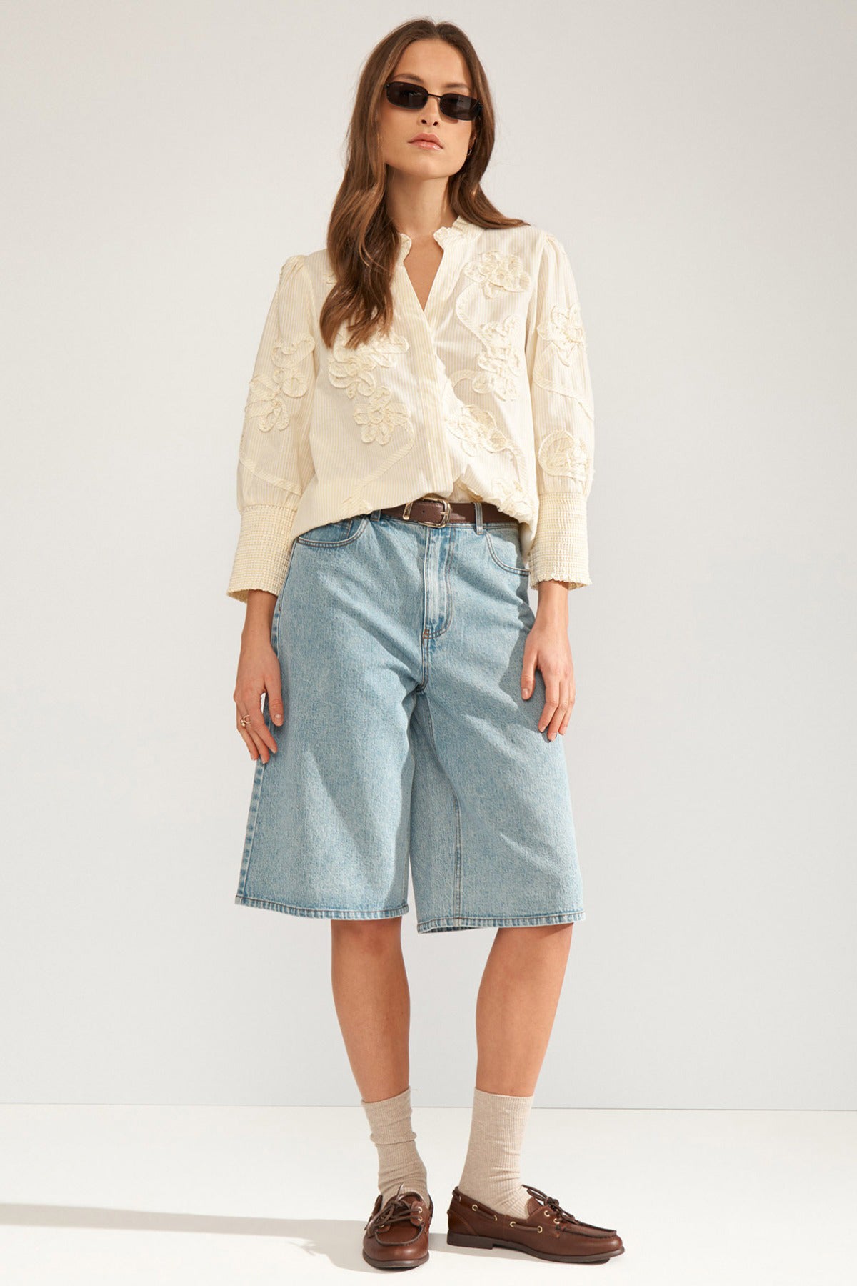Hvid stribet bluse med broderi, trekvart ærmer, rund hals og knapper foran.