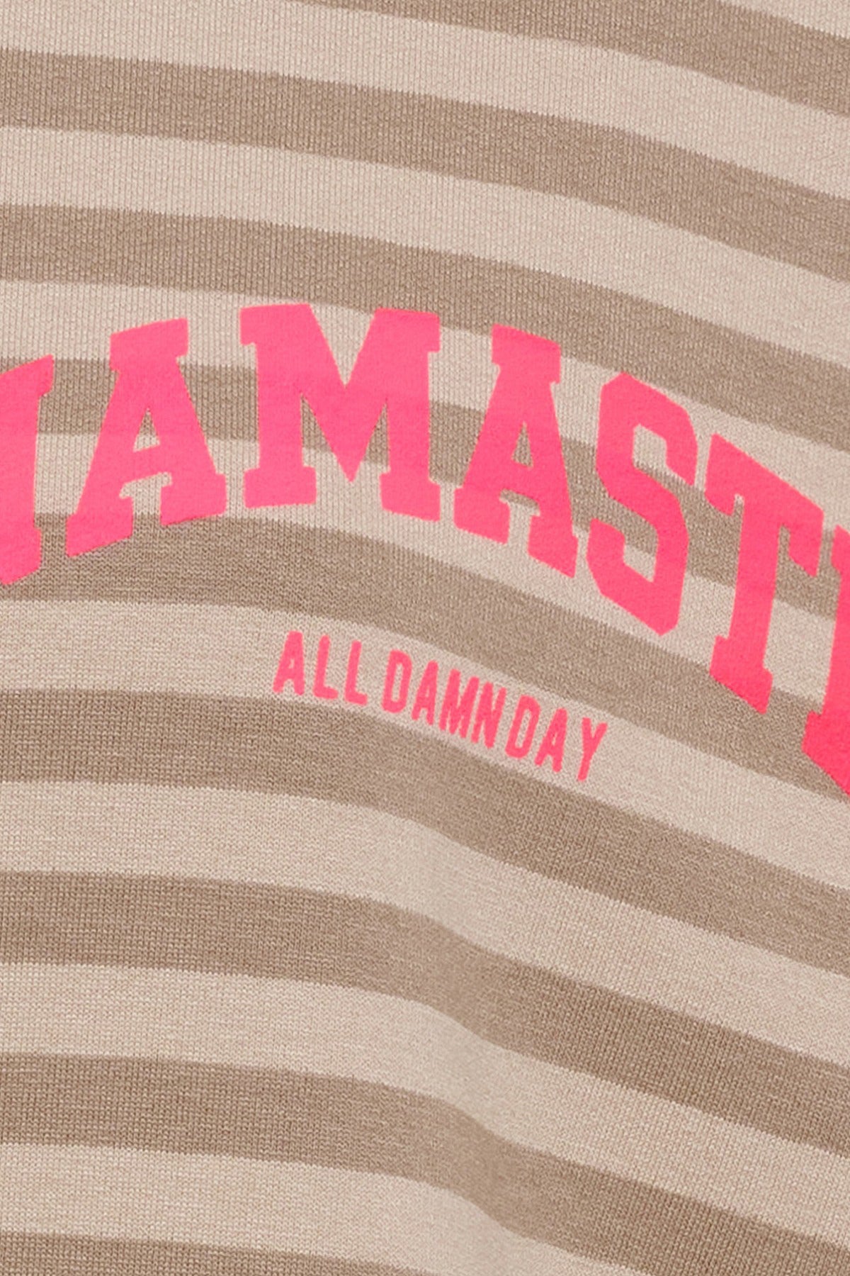 Langærmet beige bluse med lysebrune striber og pink tekstprint "NAMASTE ALL DAMNDAY".