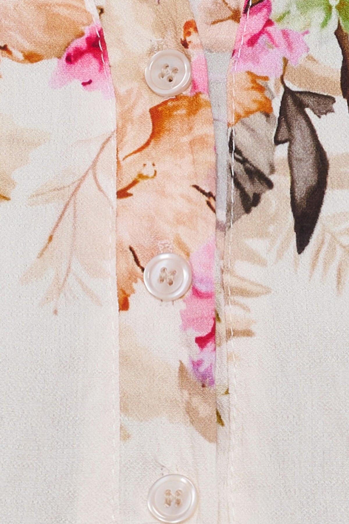 Detaljeret camel-bluse med blomsterprint og skjulte knapper i perlemor.