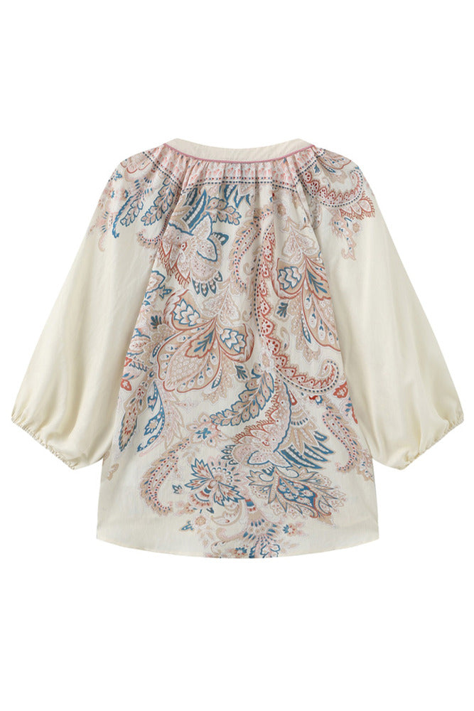 Let, cremefarvet bluse med 3/4 ærmer og blødt, mønstret design foran og bagpå.