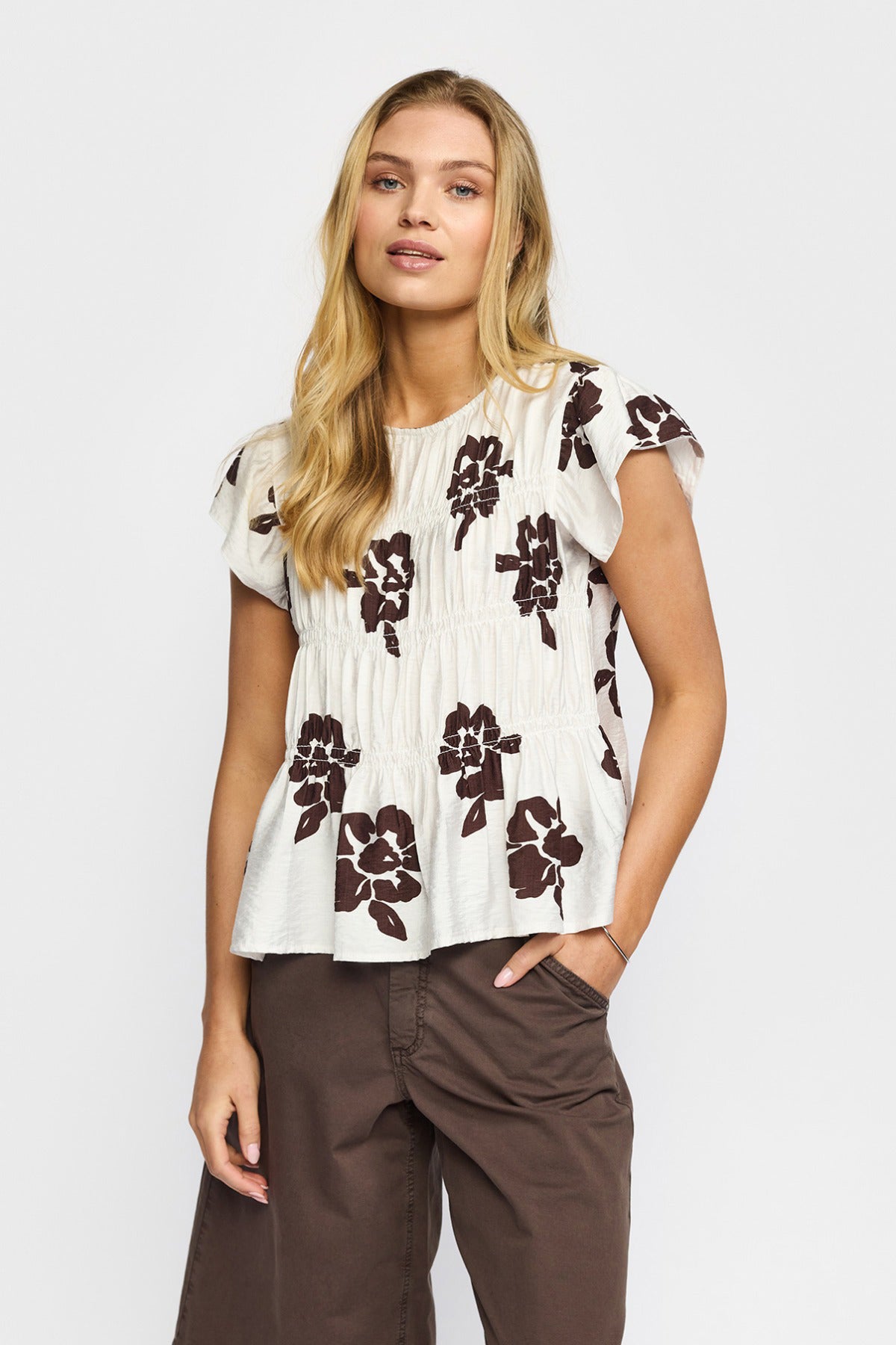 Hvid kortærmet bluse med brune blomsterprint og løstsiddende pasform.