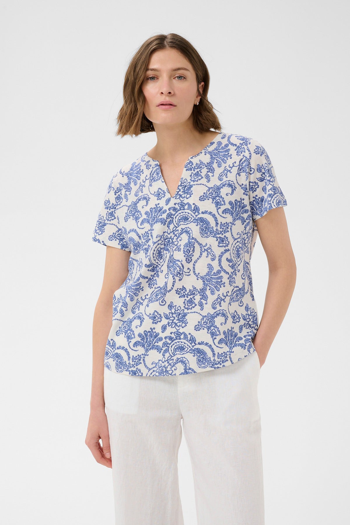 Kortærmet bluse med blå paisleyprint og v-hals i let materiale.