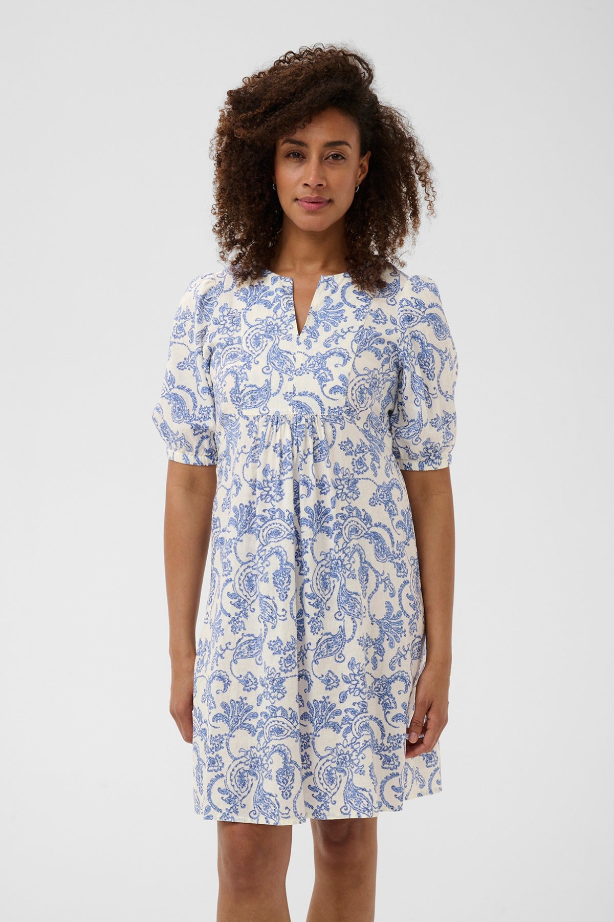 Kortærmet hør-viskose kjole med blå og hvide paisley blomsterprint, løs pasform og v-hals.