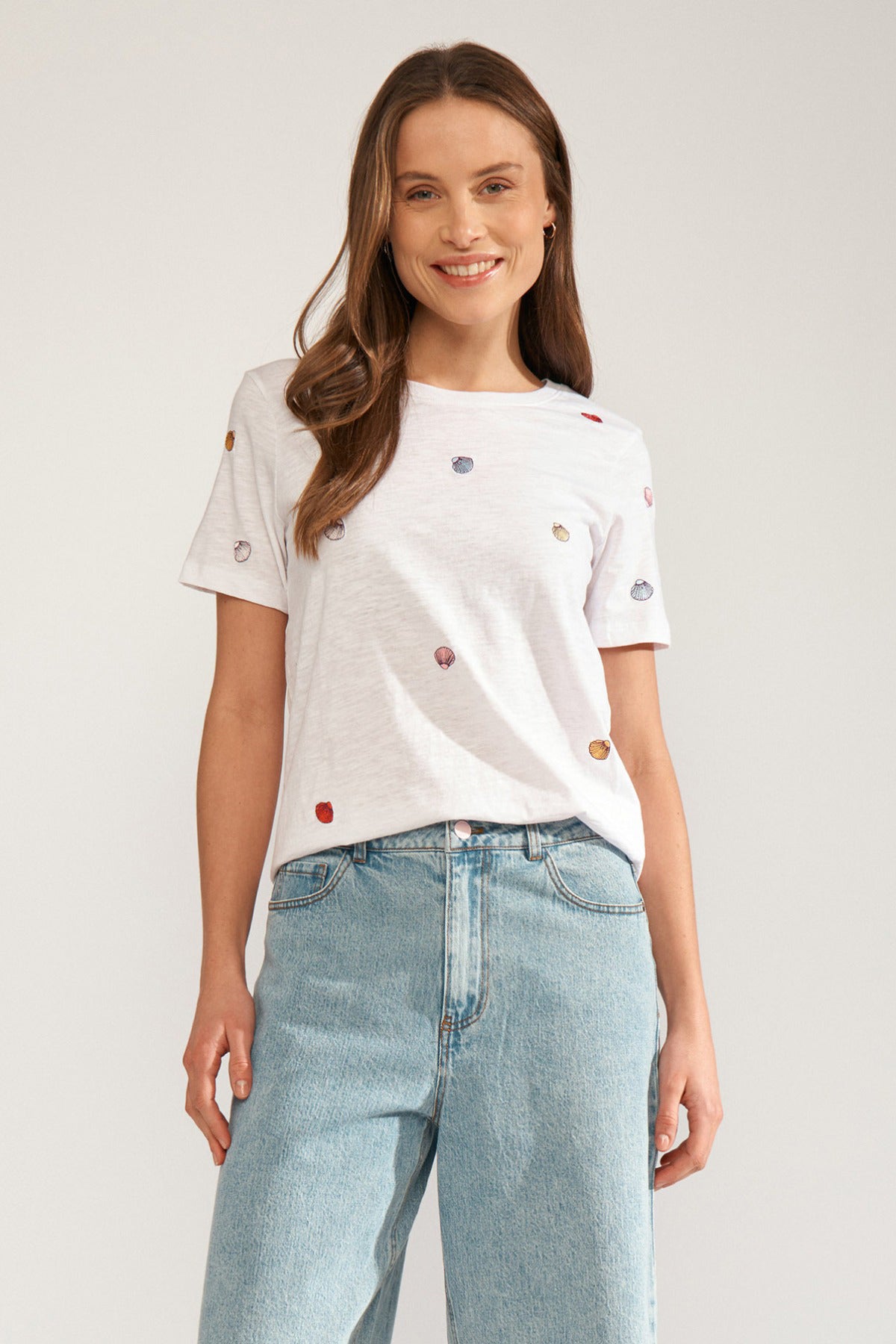 Hvid t-shirt med korte ærmer og broderede små muslingedetaljer i flere farver.