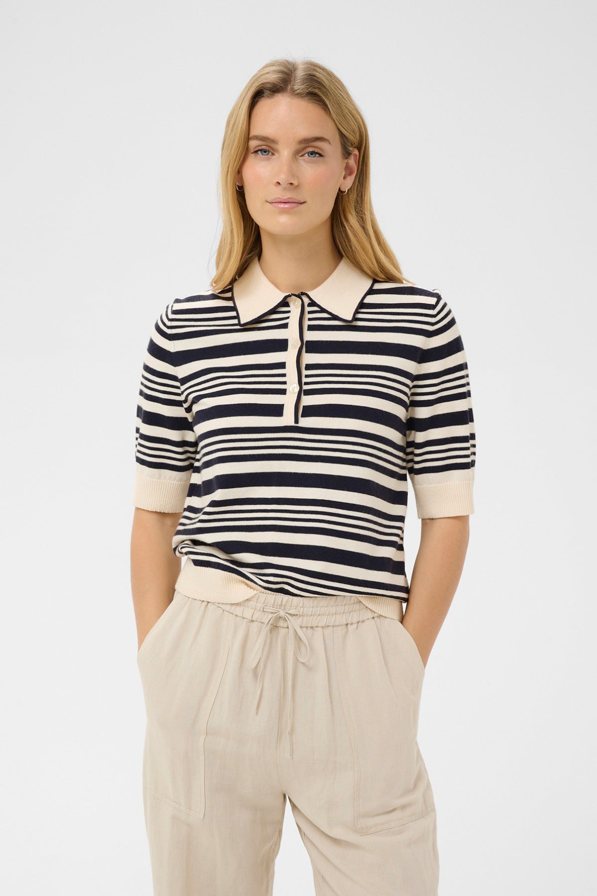 Kortærmet poloshirt i beige og mørkeblå med uregelmæssige striber og krave i kontrast.