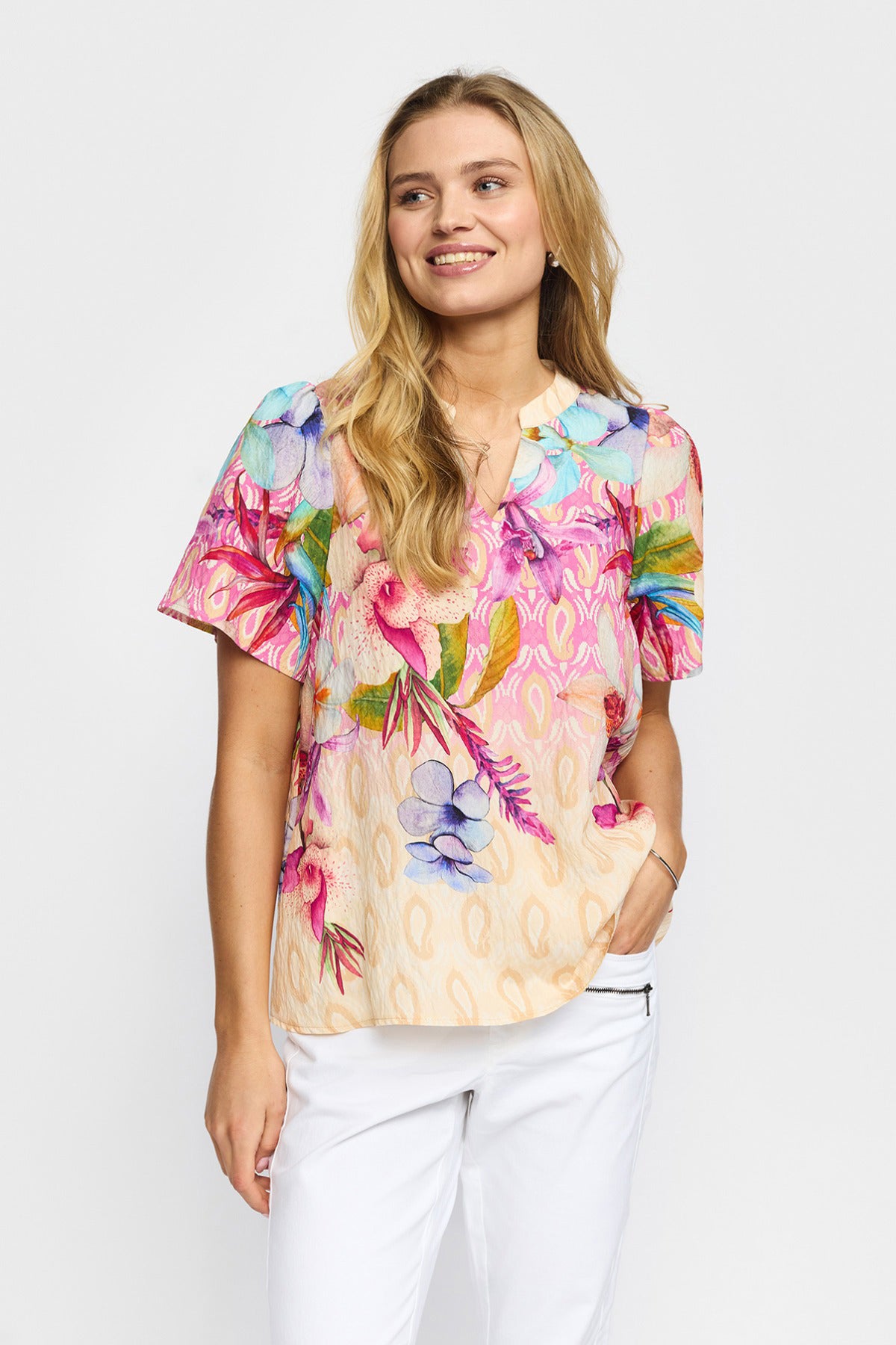 Kortærmet bluse med farverigt blomsterprint i rosa, blå og grønne nuancer, rund hals og løs pasform.