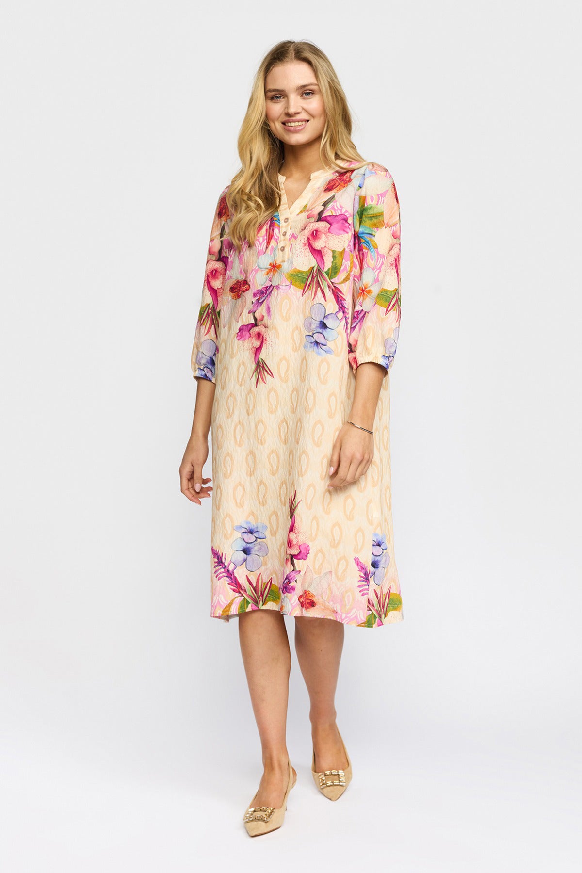 Beige midilængde kjole med blomsterprint og trekvartærmer, afslappet pasform.