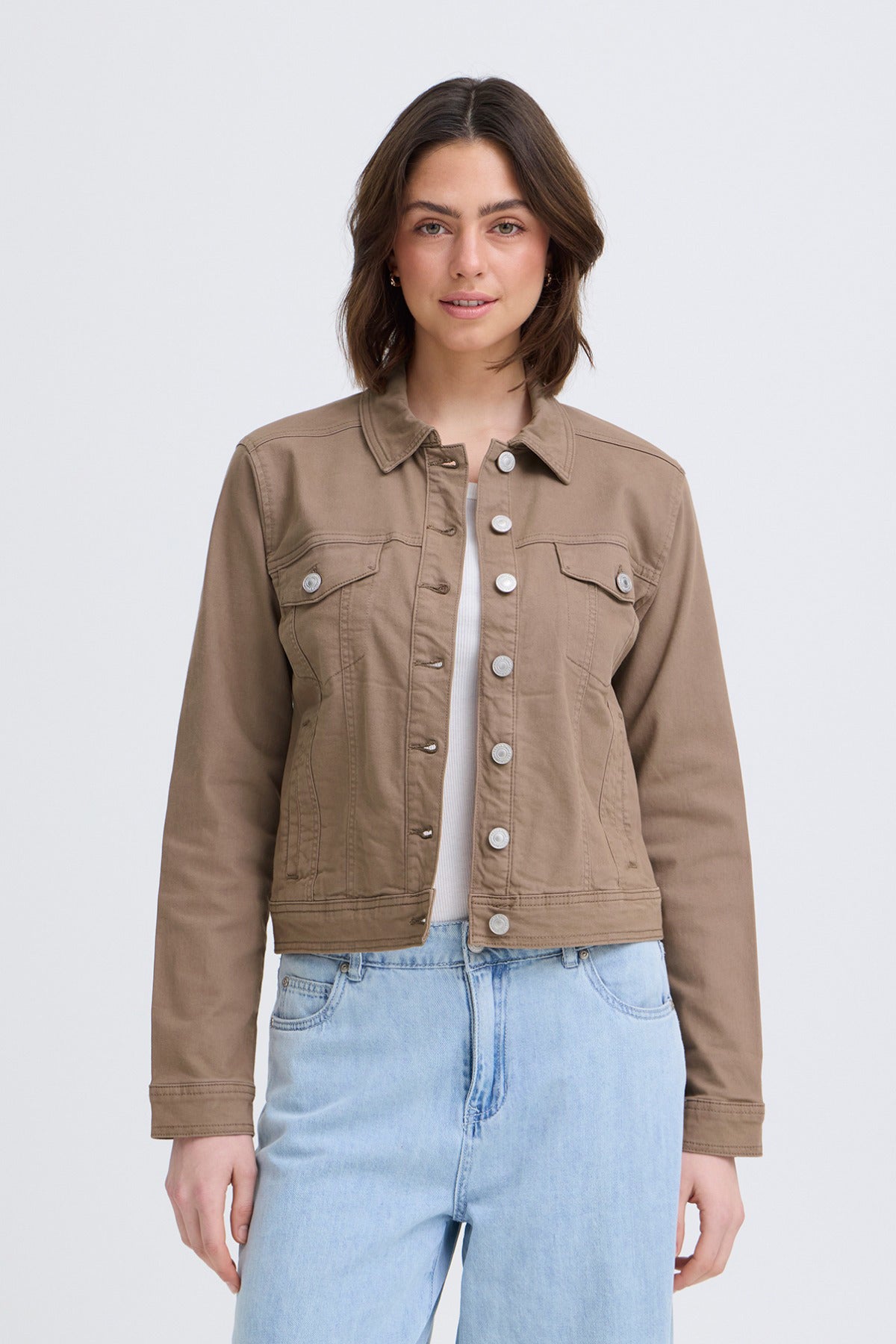 Beige elastisk denimjakke med knaplukning og brystlommer, figursyet pasform.