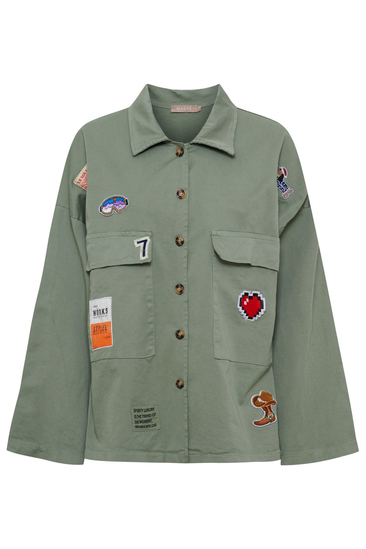 Grøn kort jakke med knapper, brystlommer og forskellige farverige broderede patches.