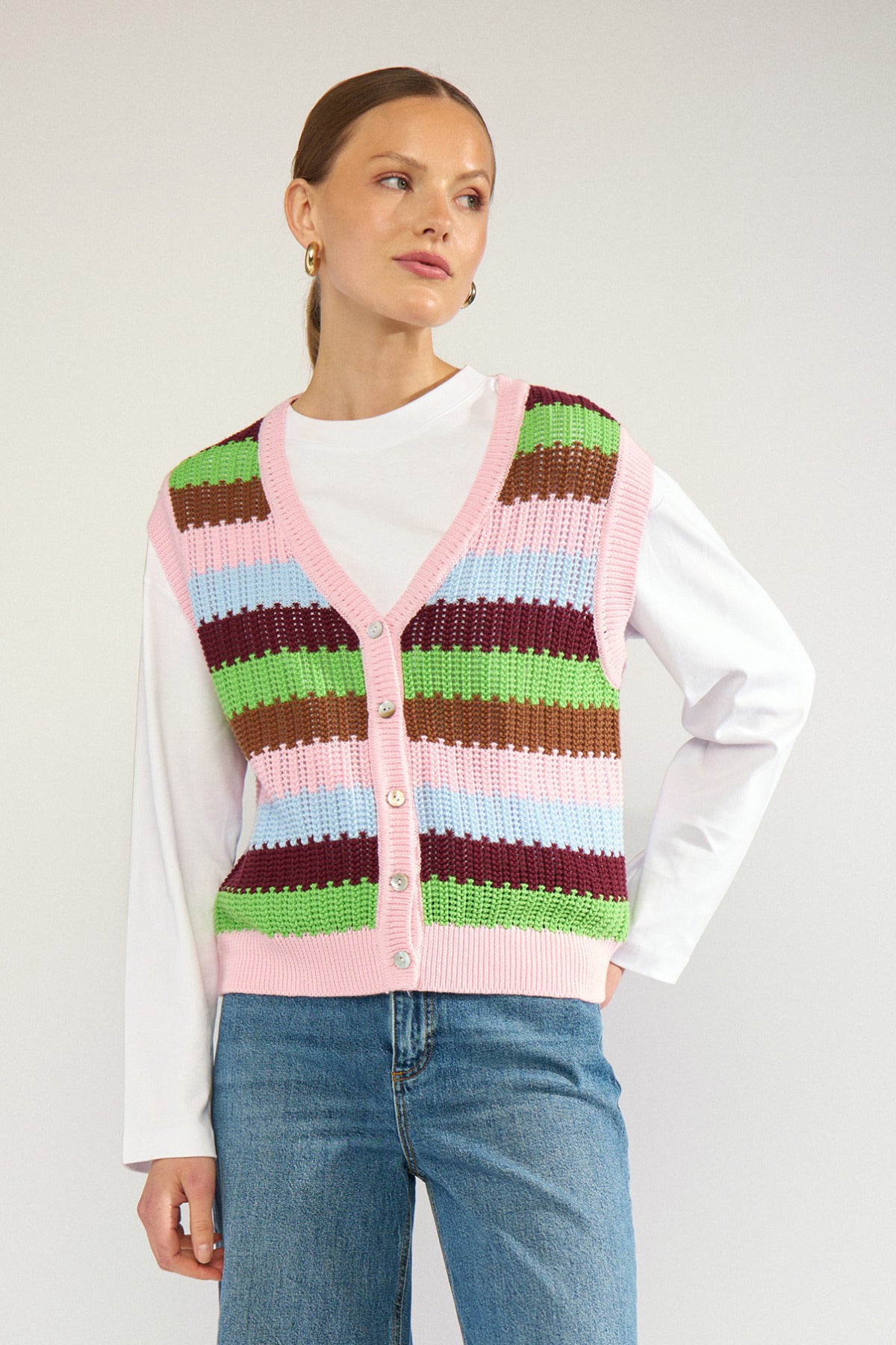 Stribet strikvest i pink, grøn, brun og lyserød med hæklede detaljer og knapper foran.