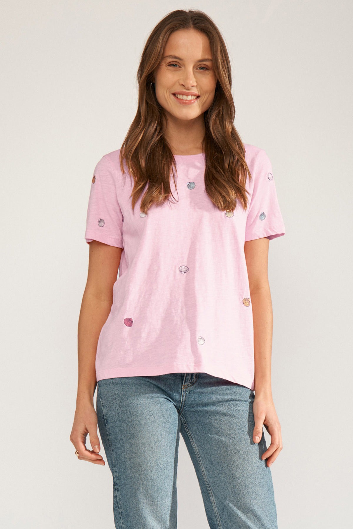 Lyserød t-shirt med korte ærmer og små broderede muslinger, rund hals og løs pasform.