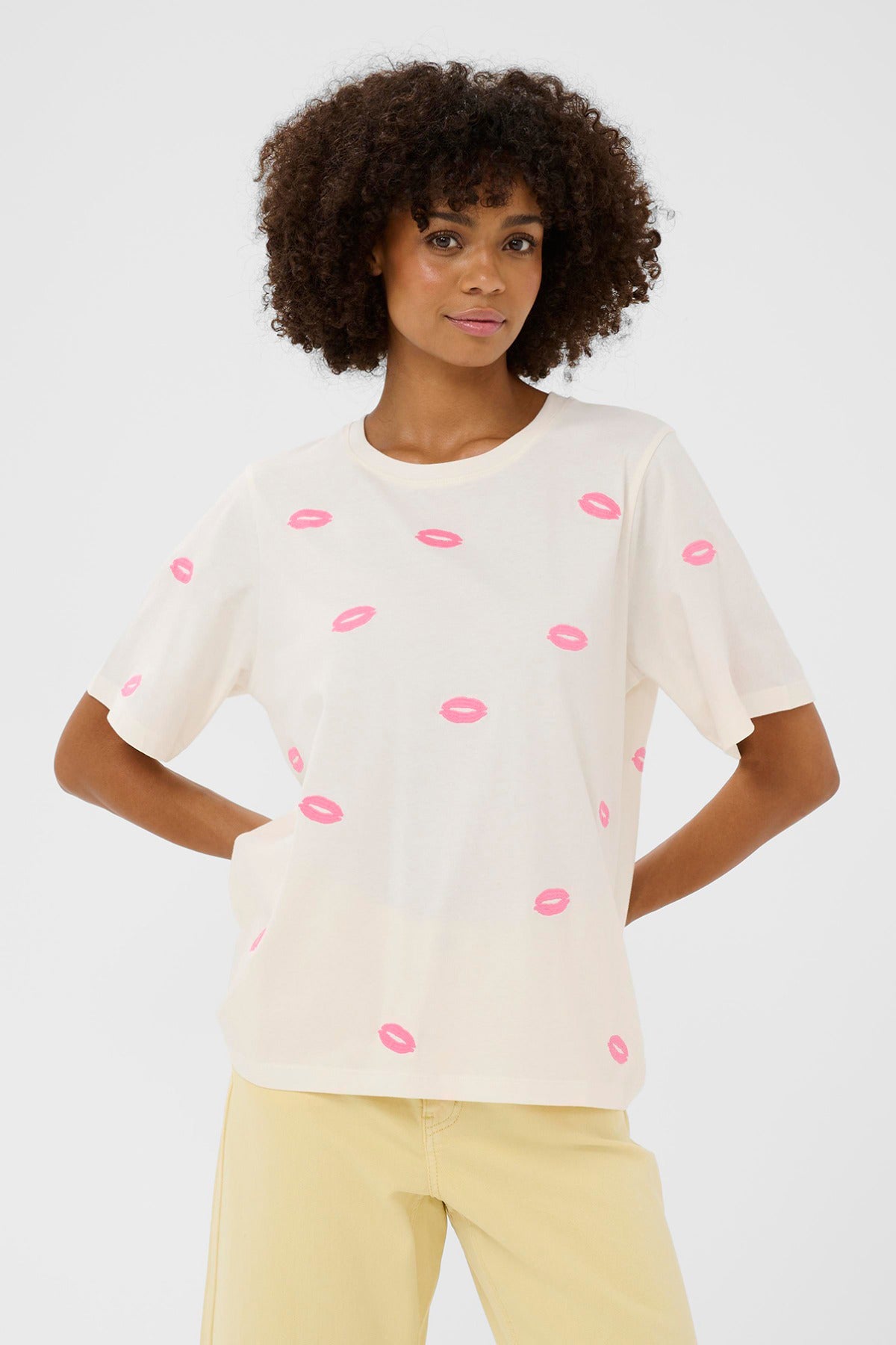 Cremefarvet kortærmet t-shirt med pink læbestiftsprint og rund hals.