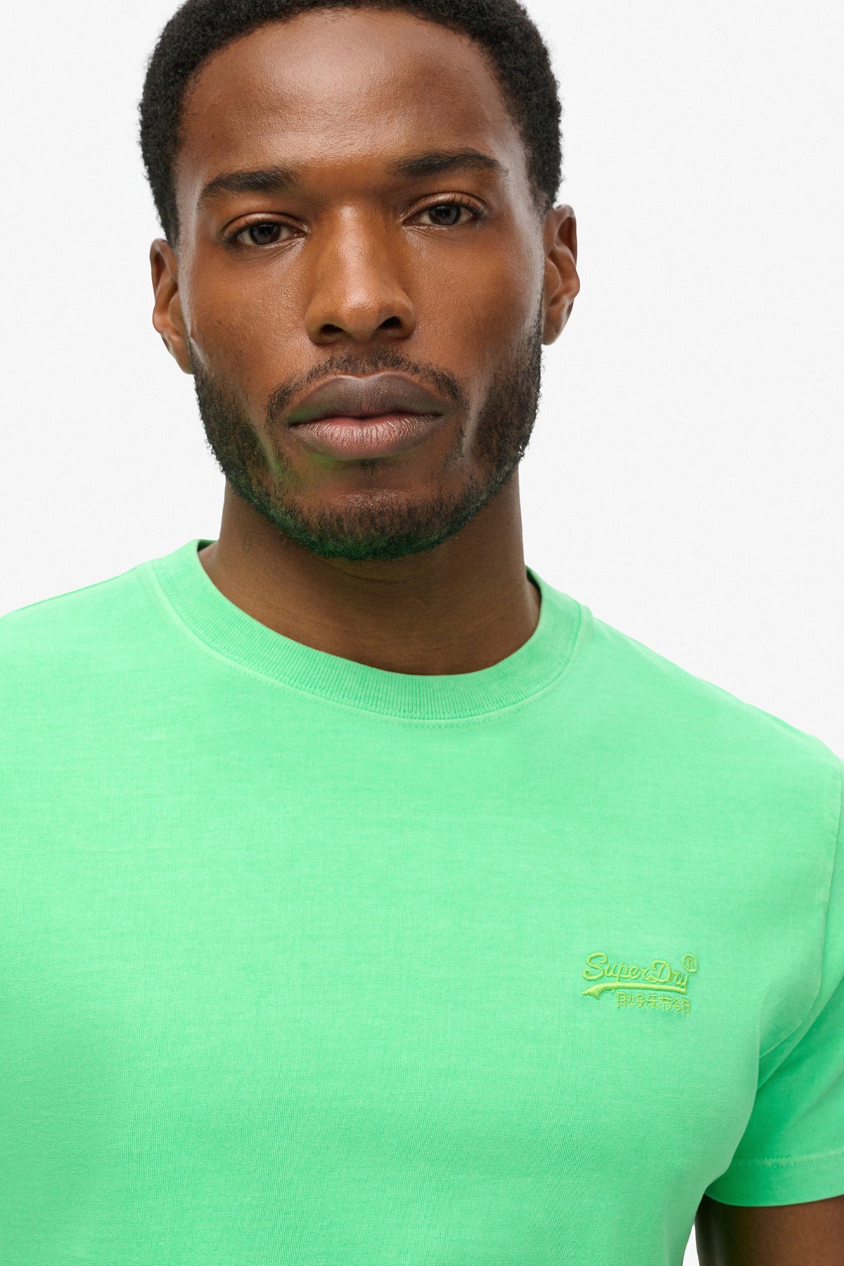 Neon limegrøn t-shirt med lille broderet logo ved brystet, rund hals og kort ærme.