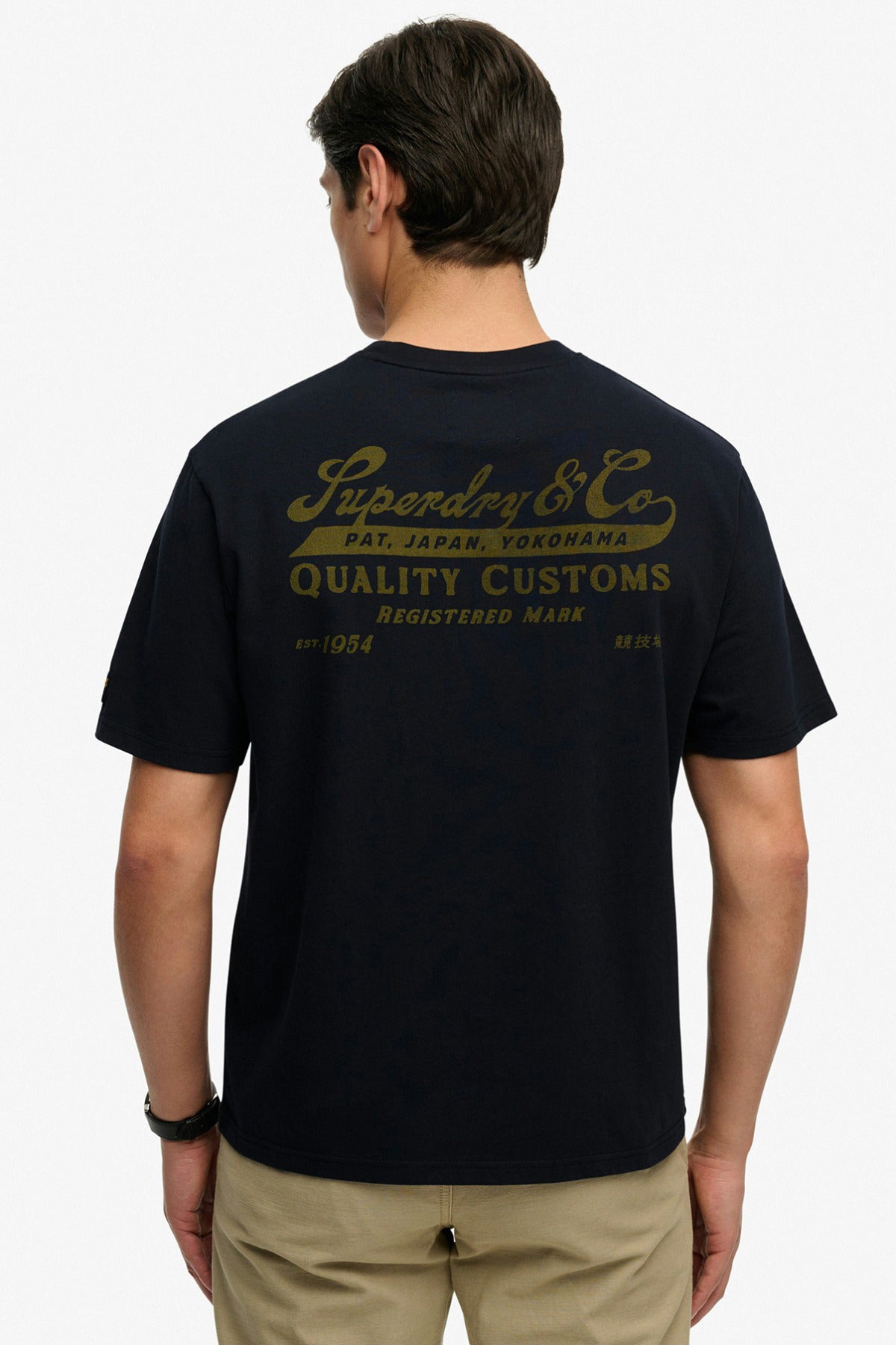 Sort kortærmet t-shirt med løs pasform og gul logo-teksttryk på ryggen.