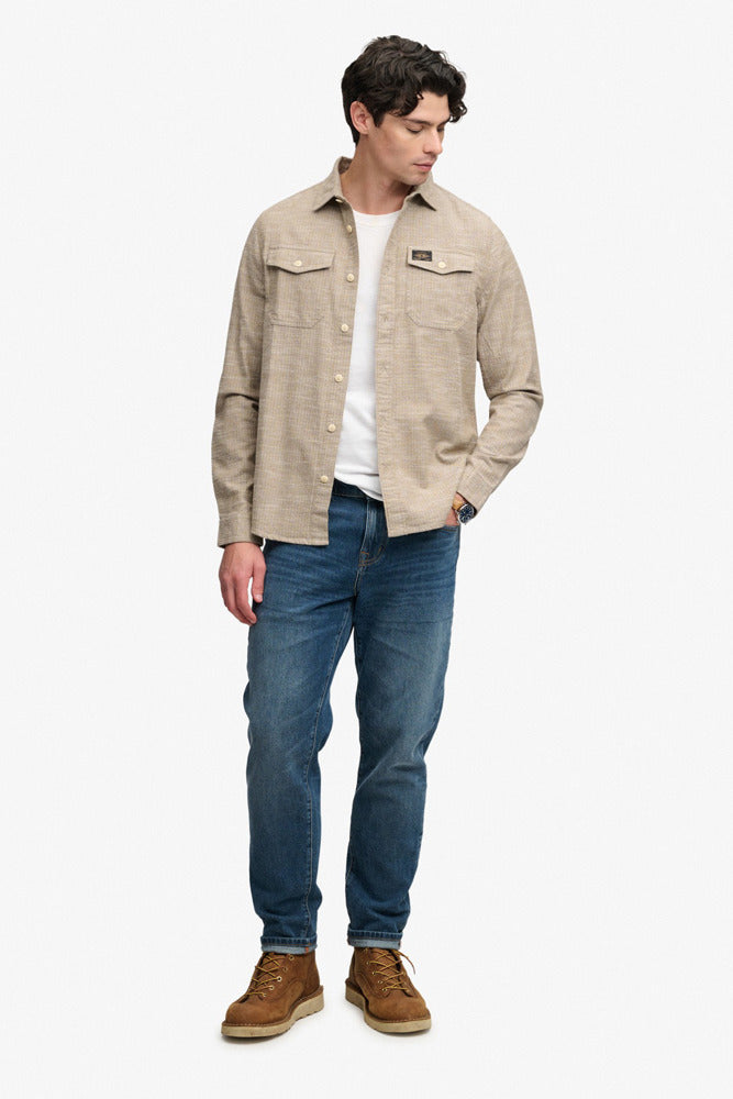 Tobacco brown skjorte med v-huls mønster, knaplukning og brystlommer, kombineret med blå jeans og brune sko.