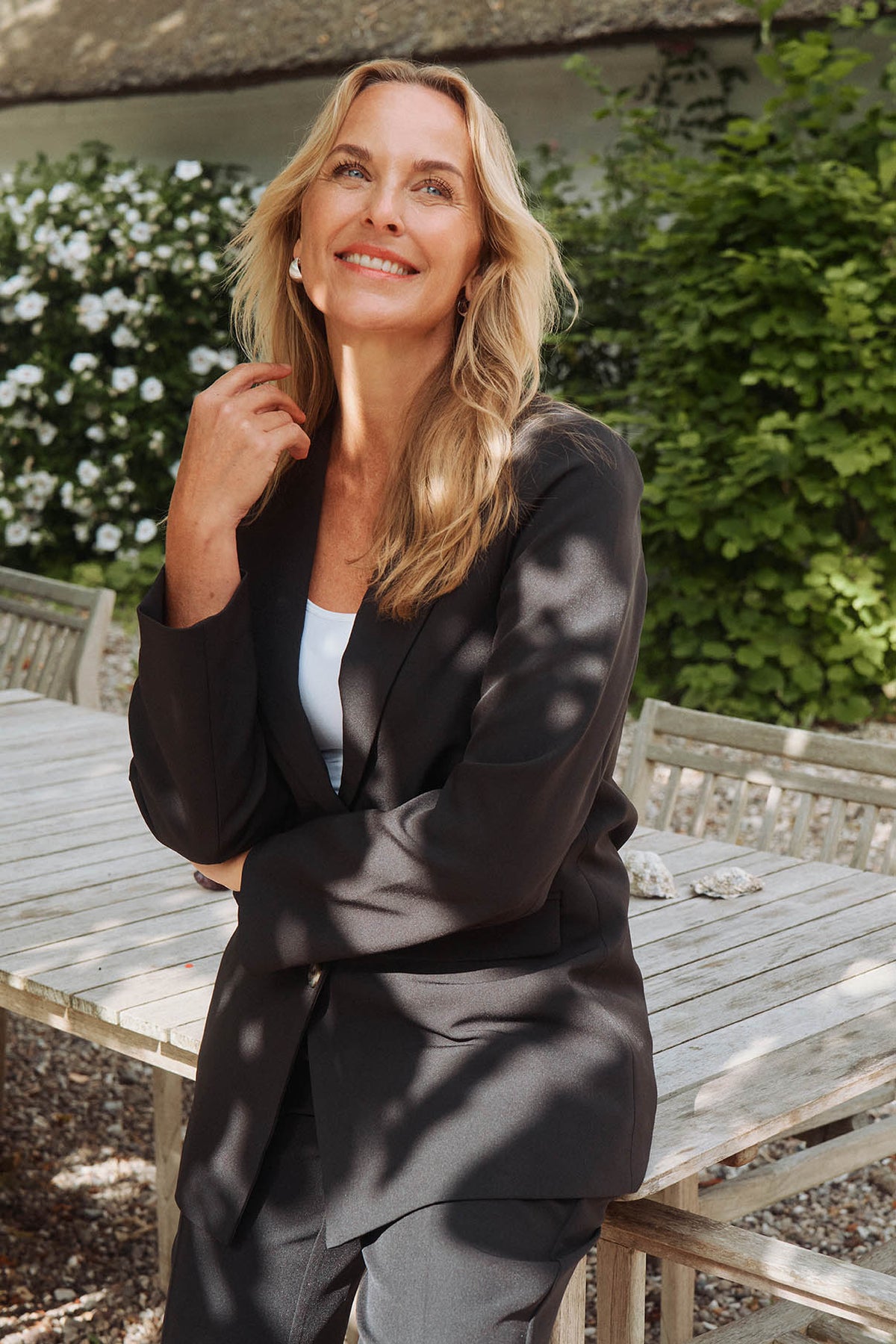 Sort klassisk blazer med revers, to lommer og enkel lukkeknap i midten.